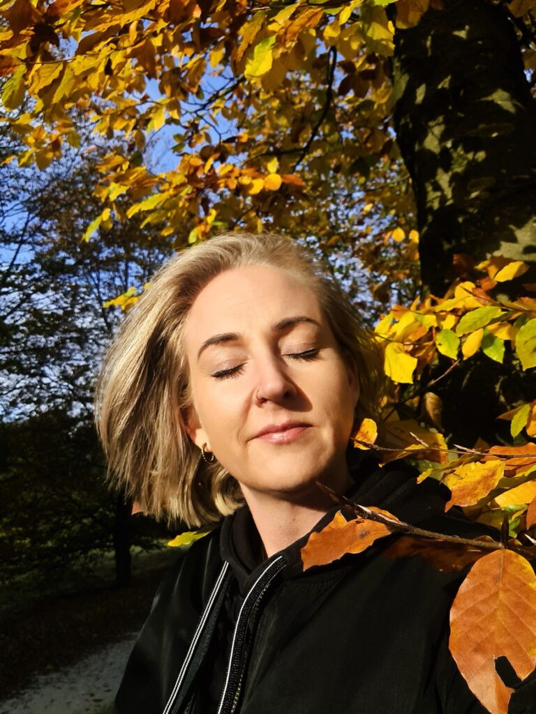 Suus genietend van de herfst zon bladeren