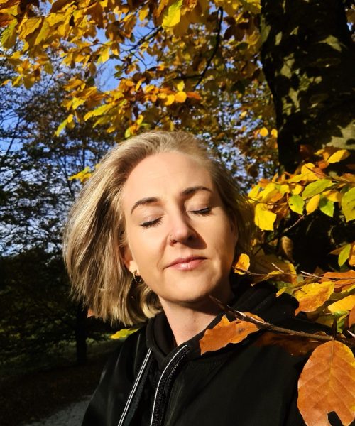 Suus genietend van de herfst zon bladeren